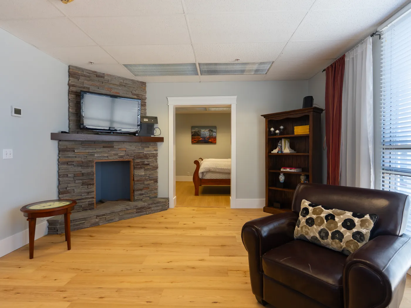 Stone fireplace vignette with restored oak flooring leading through to the bedroom display