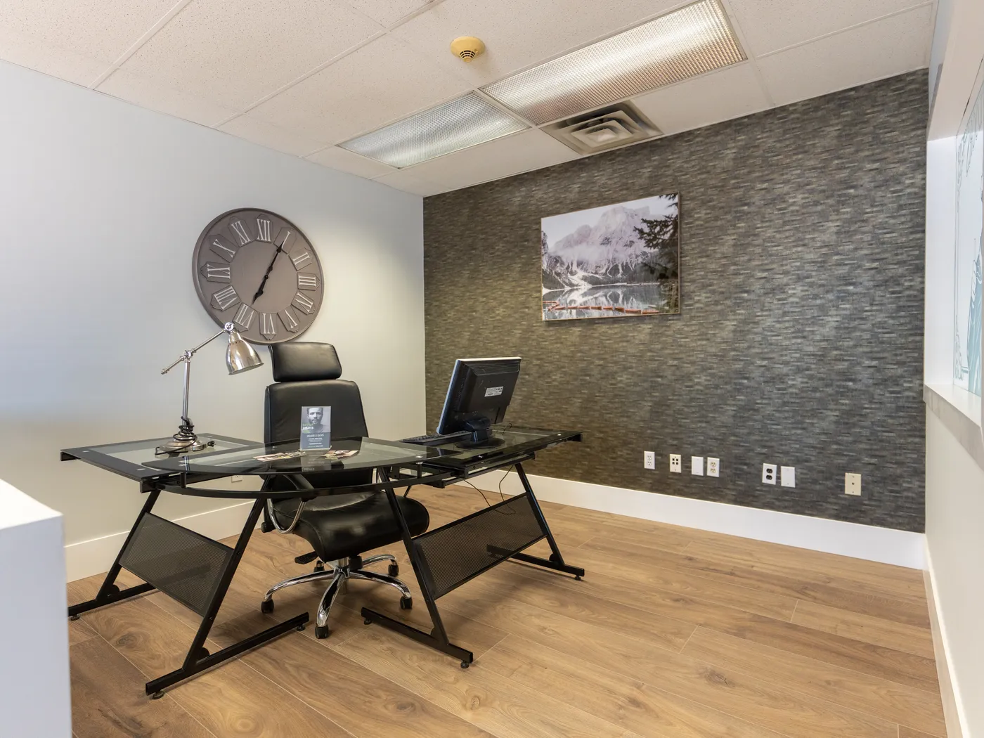 Office vignette with restored dark plank flooring and feature wall