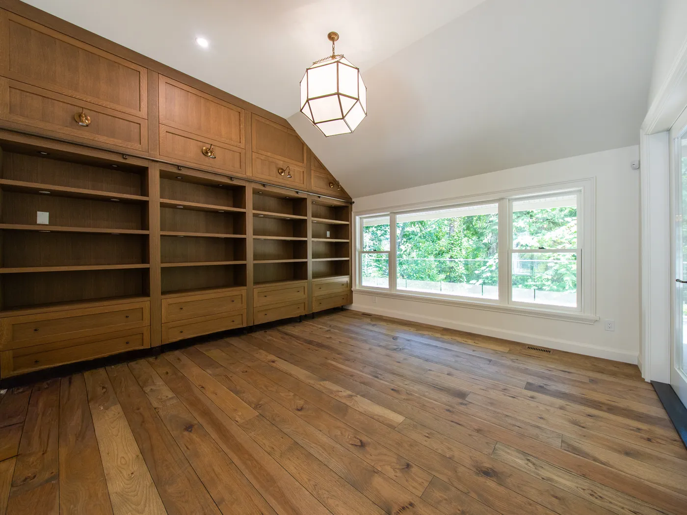 Wall of oak built-in shelving with oak flooring