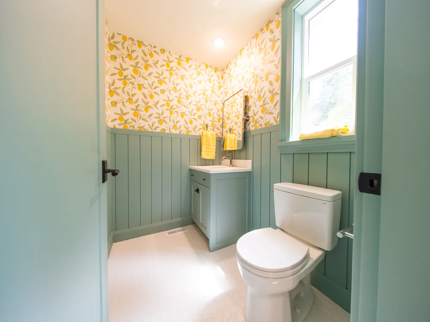 Powder room with floral wallpaper and sage wainscotting