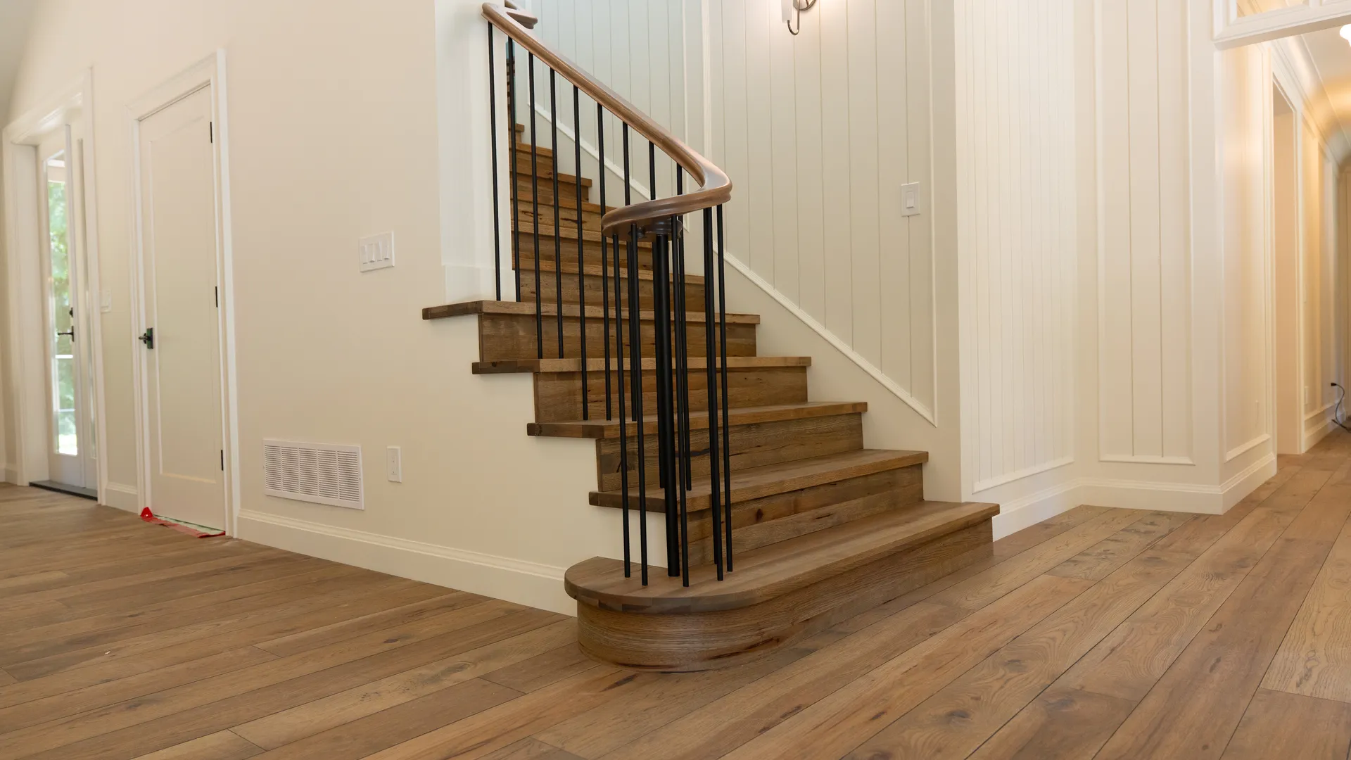 Oak staircase with black metal spindles and shiplap walls