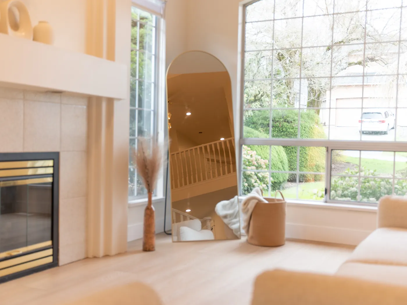 Living room with tiled fireplace and arched mirror