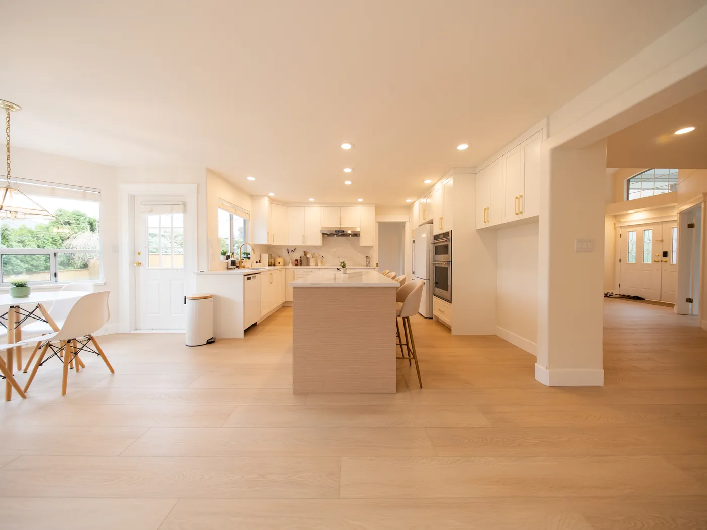 White kitchen with island opening to the dining area